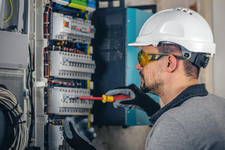 Eletricista dando manutenção em disjuntor elétrico